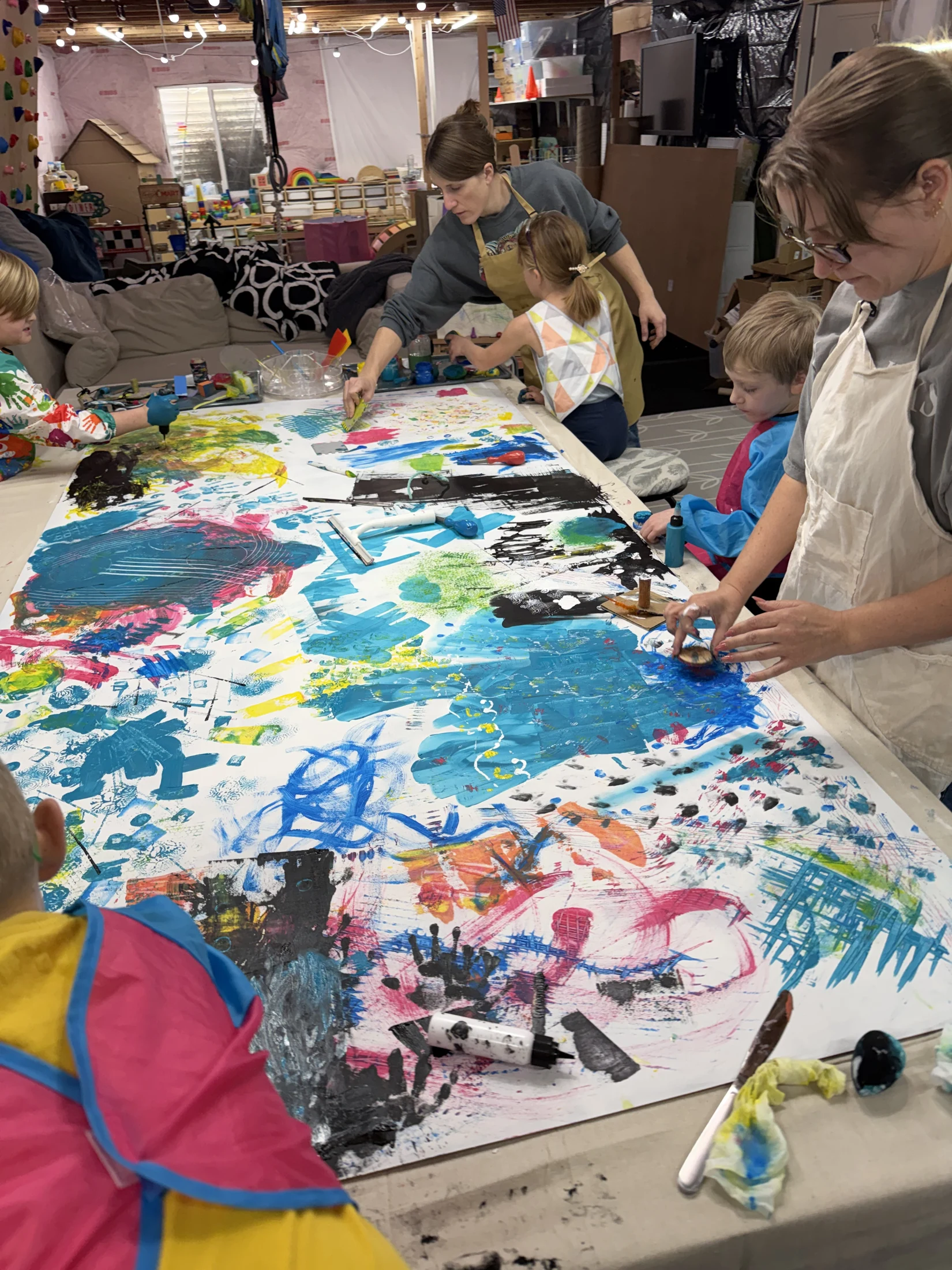Young artists working together on a large colorful painting