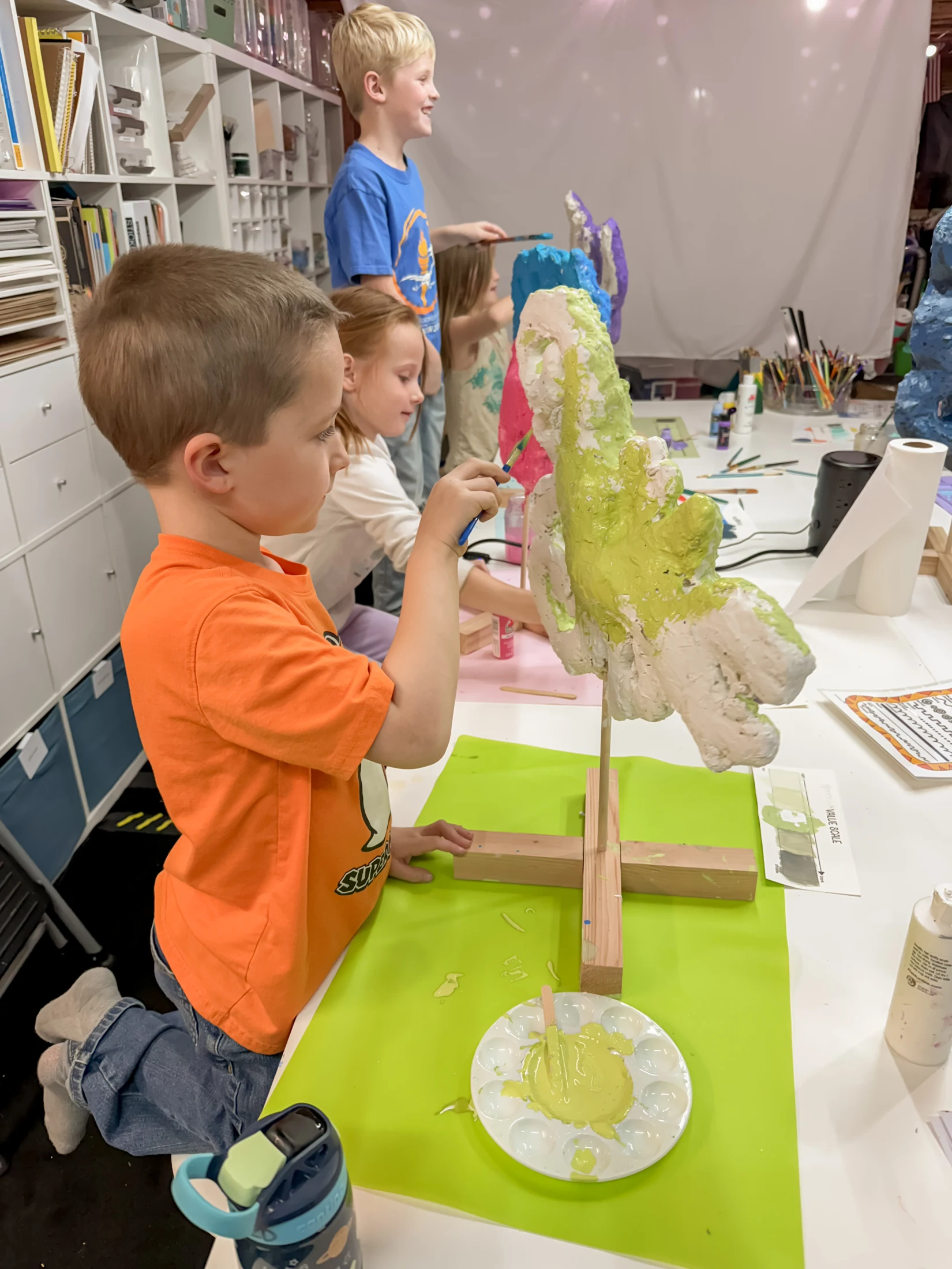 Children painting colorful cactus sculptures together