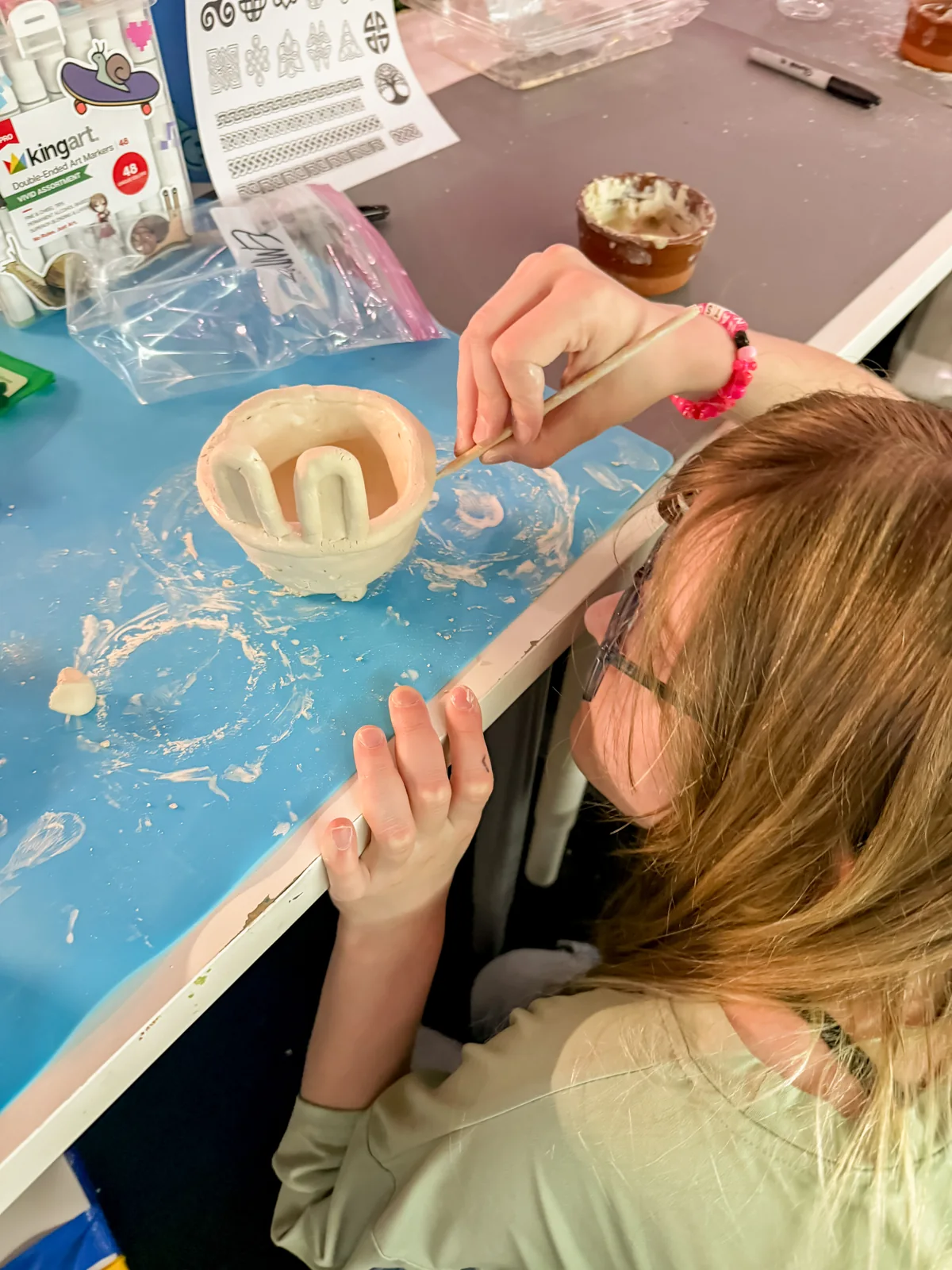 An artist working with paint and a brayer at a printmaking table