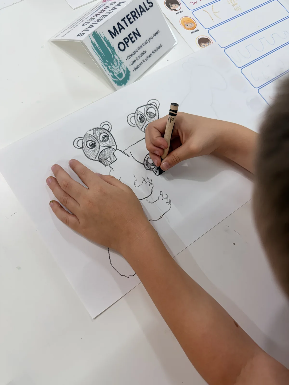An artist drawing a small subject in a sketchbook
